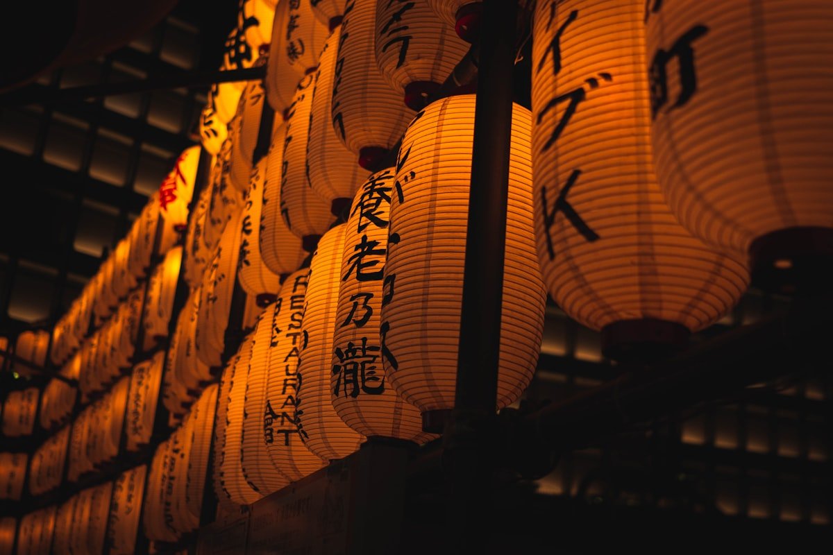 honne meaning — glowing red Japanese lanterns with kanji script hanging in a night shrine