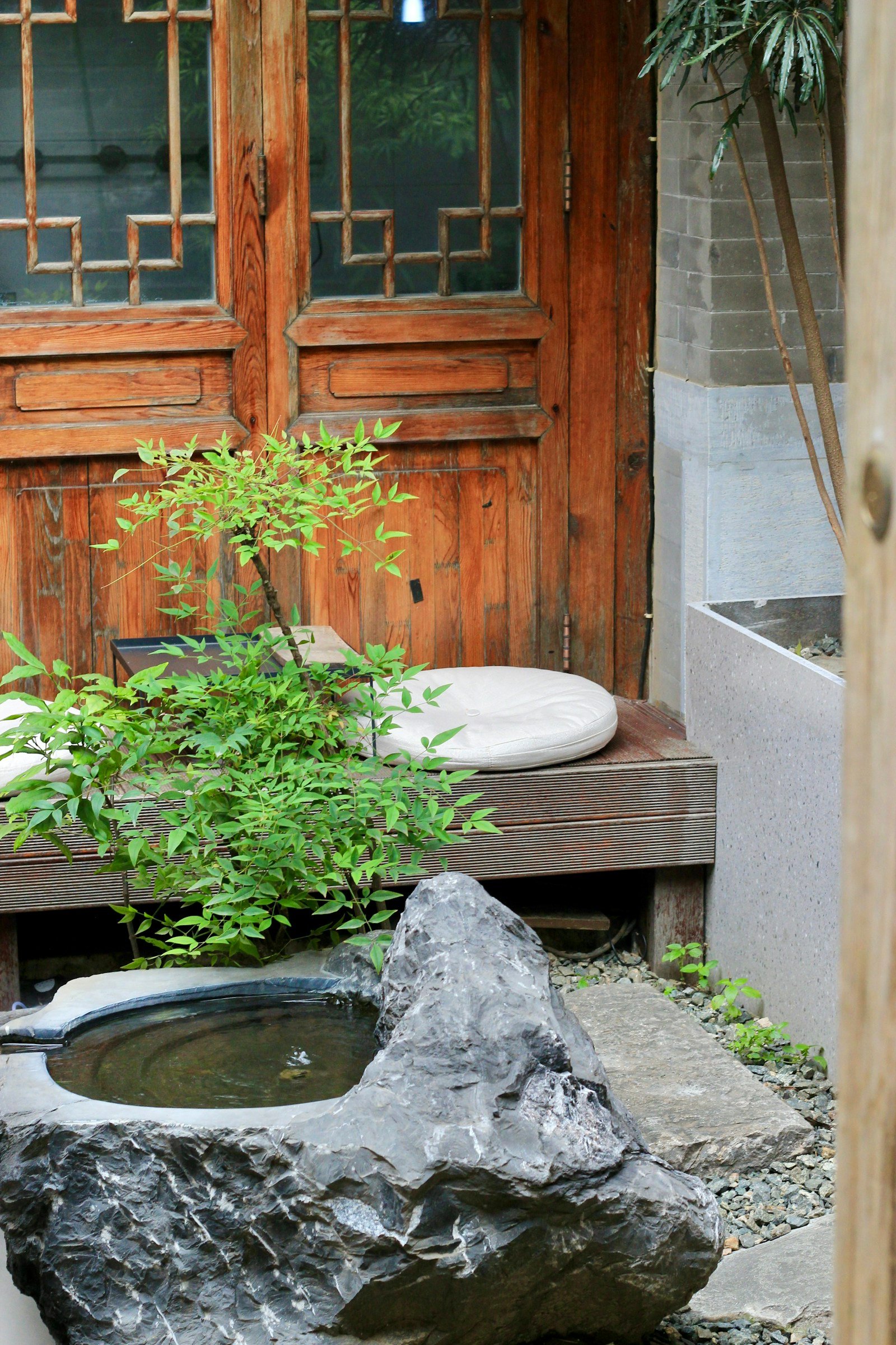 nagomi meaning — a traditional Japanese stone water basin with green plants, evoking quiet harmony